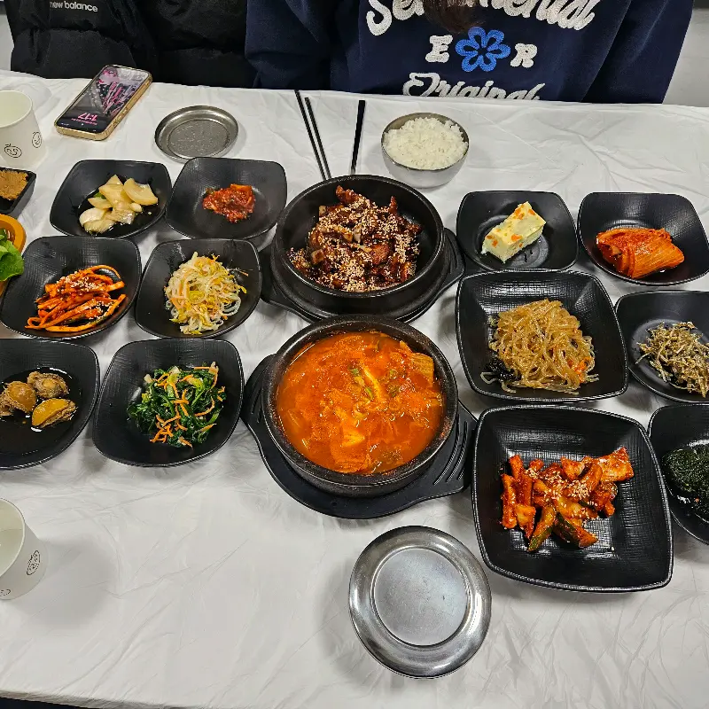 테이블 가득 차려진 밑반찬과 메인 메뉴