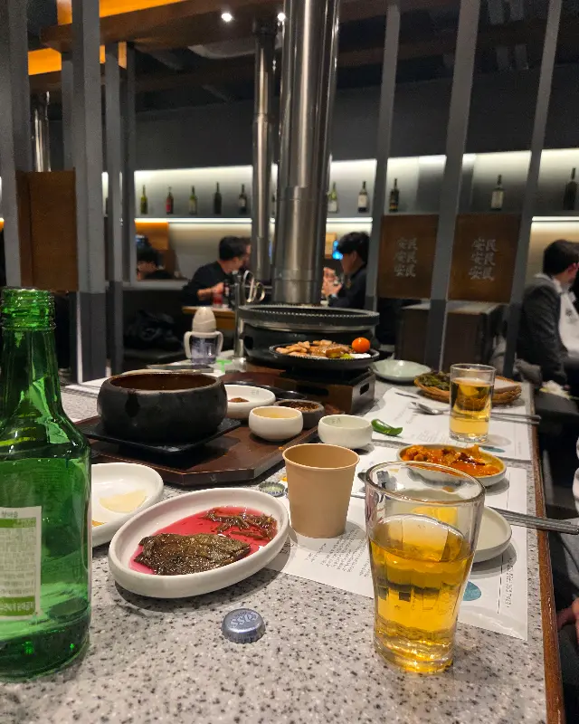 테이블 위에 다양한 밑반찬과 술잔이 놓여 있는 모습