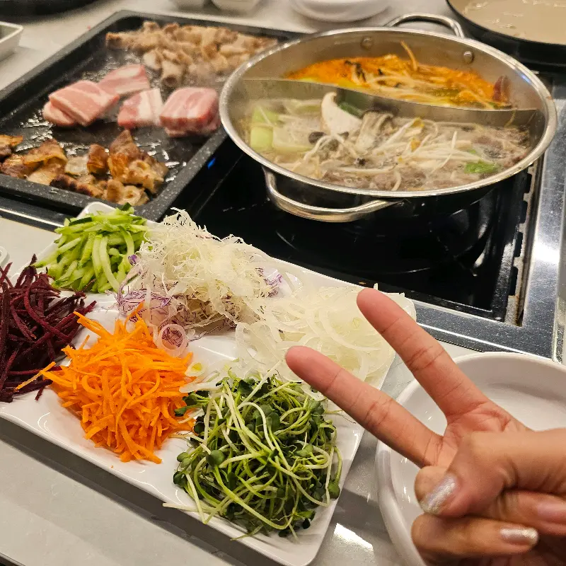 월남쌈 재료와 샤브샤브, 삼겹살이 함께 놓인 테이블