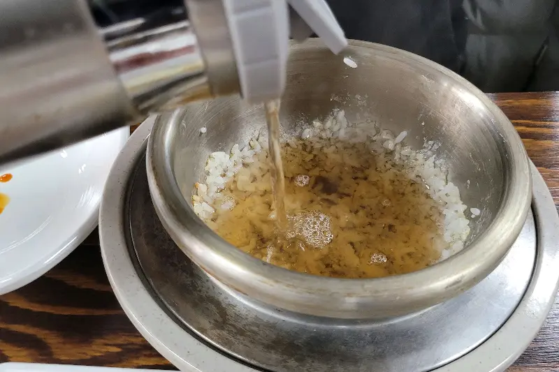 솥밥에 숭늉을 부어 먹는 모습