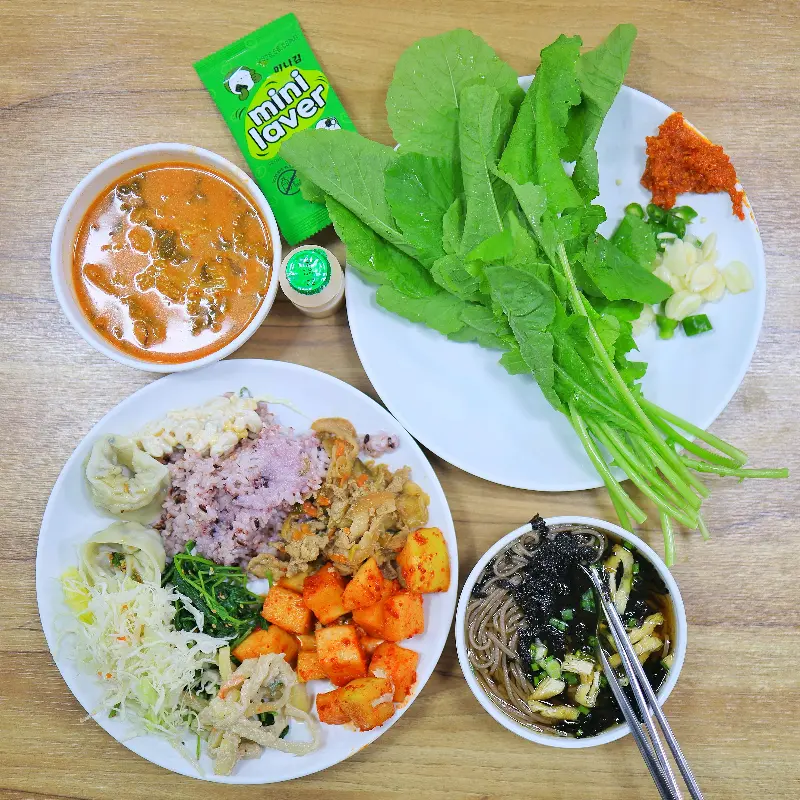 다양한 반찬과 쌈 채소가 있는 뷔페식 식탁