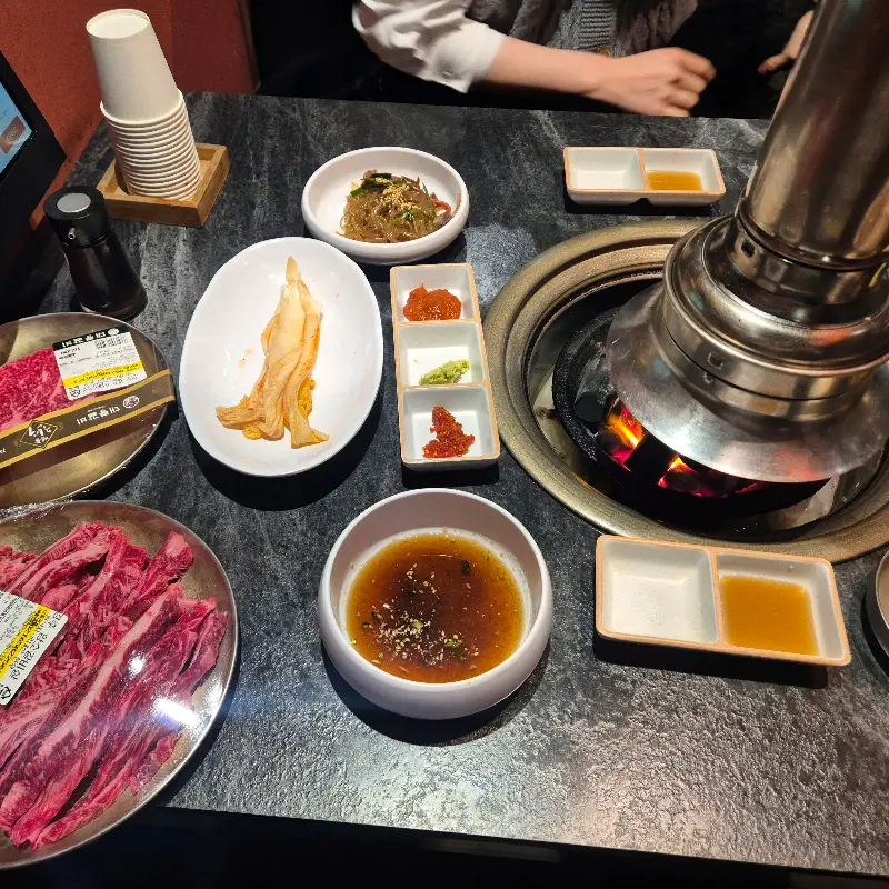 정갈하게 차려진 밑반찬과 숯불