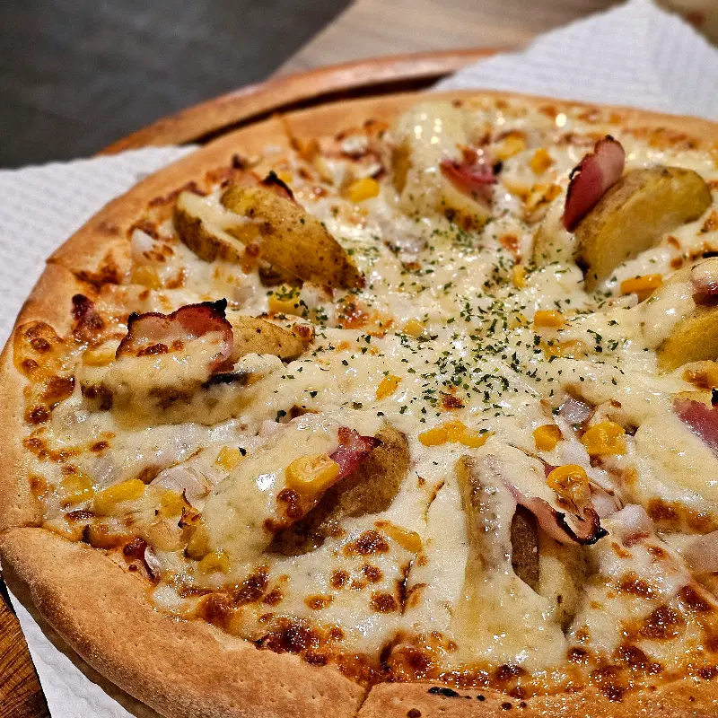 피자 위에 토핑된 감자와 베이컨