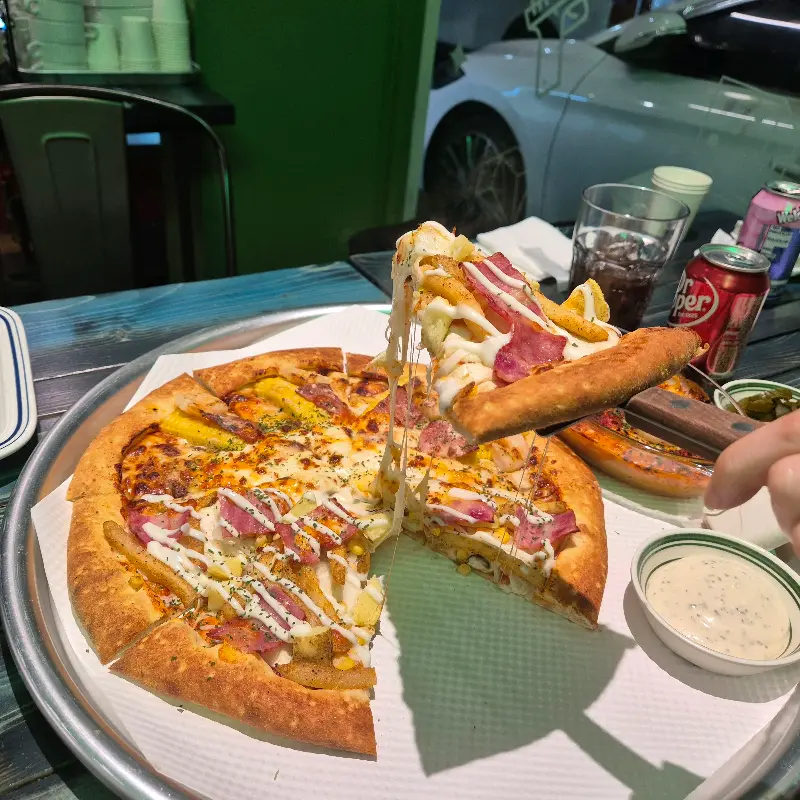 한 조각 들어올린 피자의 쫄깃한 치즈