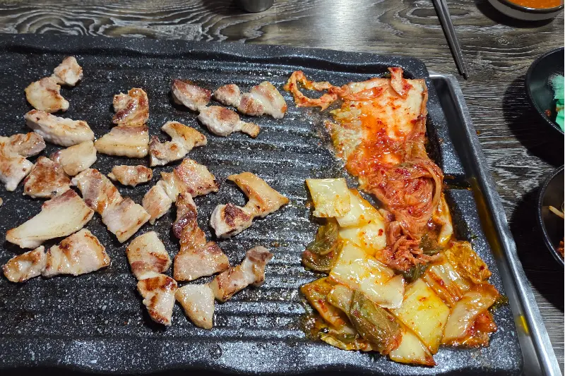 불판 위의 삼겹살과 김치