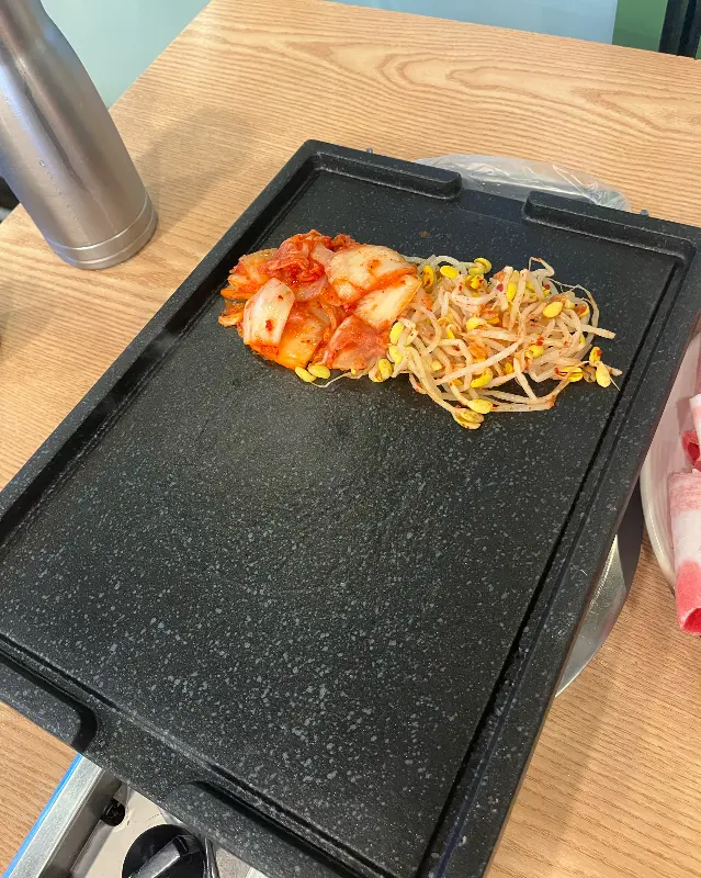 불판 위에 김치와 콩나물