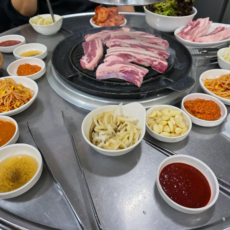 다양한 밑반찬과 쌈 채소가 가득 차려진 테이블