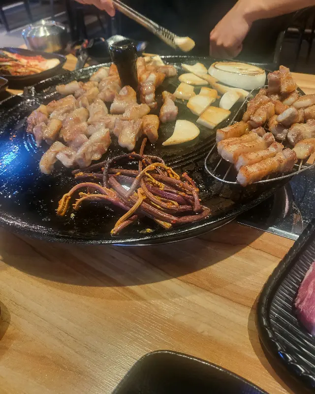 솥뚜껑 위에서 노릇하게 구워진 삼겹살의 모습