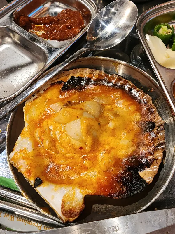 치즈가 듬뿍 녹아 있는 치즈 가리비 구이의 클로즈업