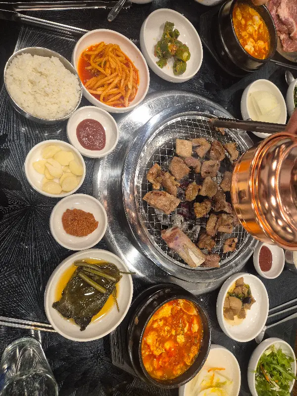 다채로운 밑반찬과 숯불에 구워지는 돼지갈비
