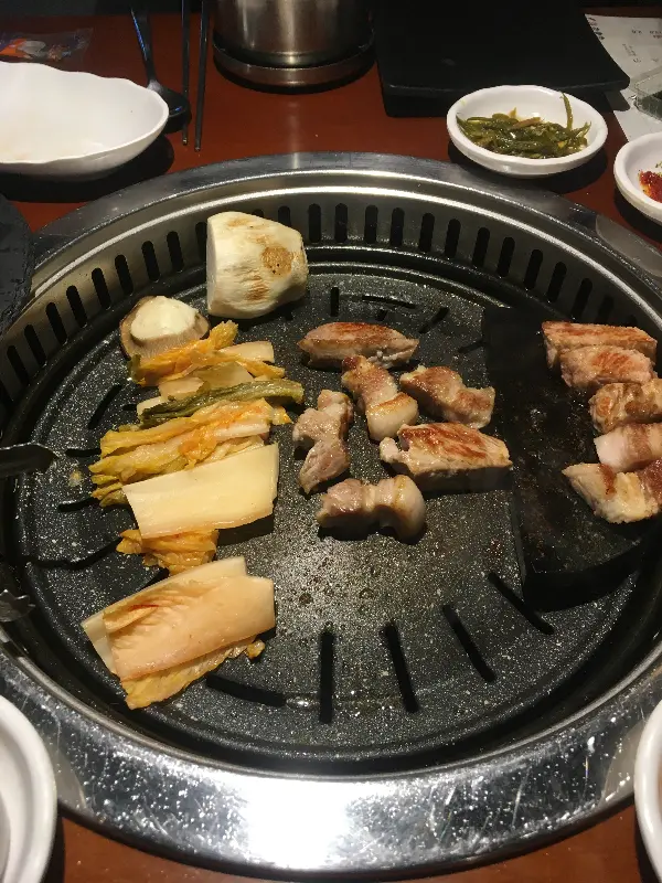 불판 위에서 익어가는 고기와 김치