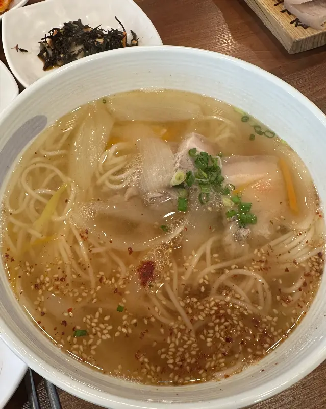 멸치 육수의 시원함이 느껴지는 멸고국수 위에는 돔베고기가 고명으로 올려져 있다.