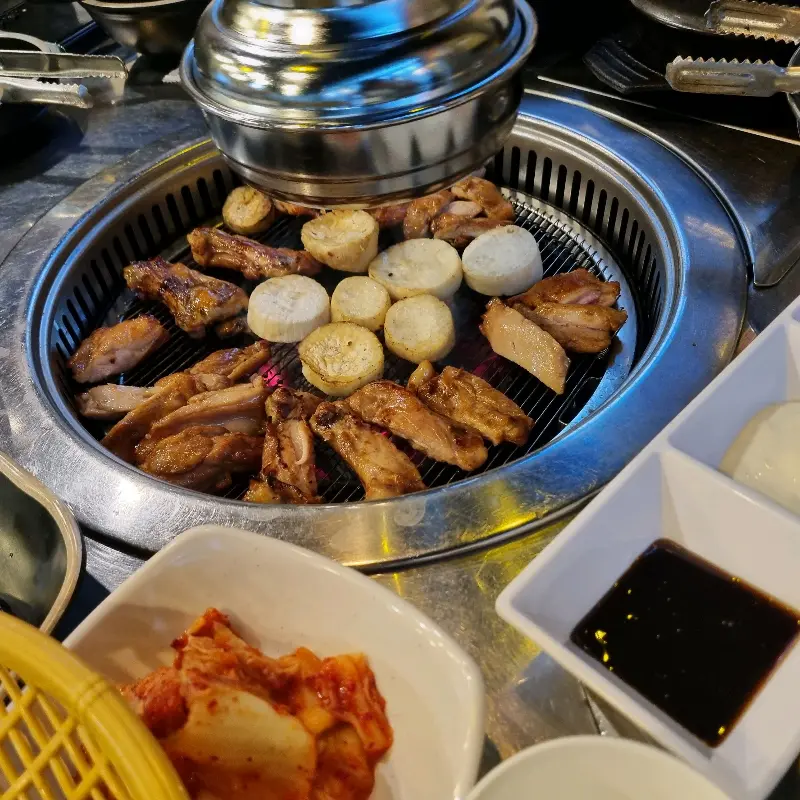 숯불 위에서 닭갈비와 떡이 익어가는 모습