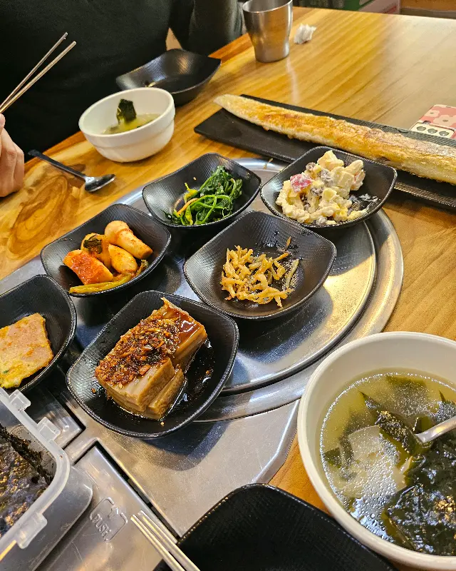 다양한 밑반찬이 담긴 흑색 사각 접시들