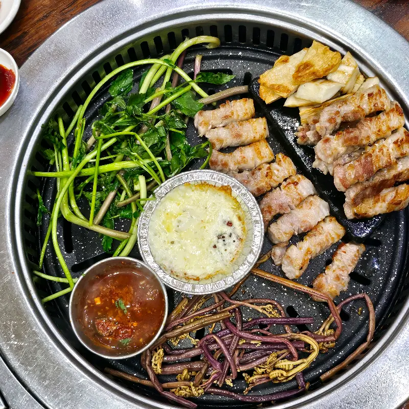 불판 가득 삼겹살, 미나리, 고사리, 버섯, 치즈