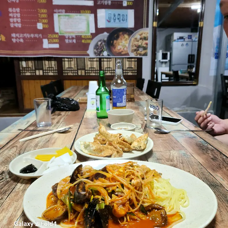 테이블 위에 놓인 짬뽕, 야끼만두, 소주병