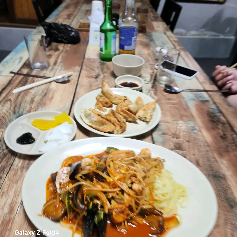 테이블 위에 놓인 짬뽕, 야끼만두, 단무지, 춘장