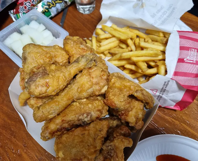 테이블 위에 놓인 치킨과 감자튀김, 무