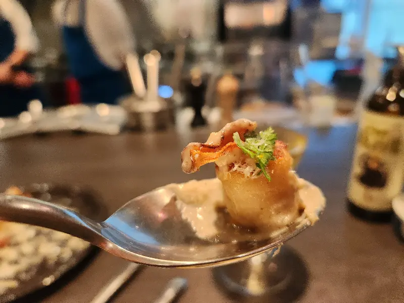 숟가락 위에 올려진 한 입 크기의 장흥삼합, 섬세한 플레이팅이 돋보인다.