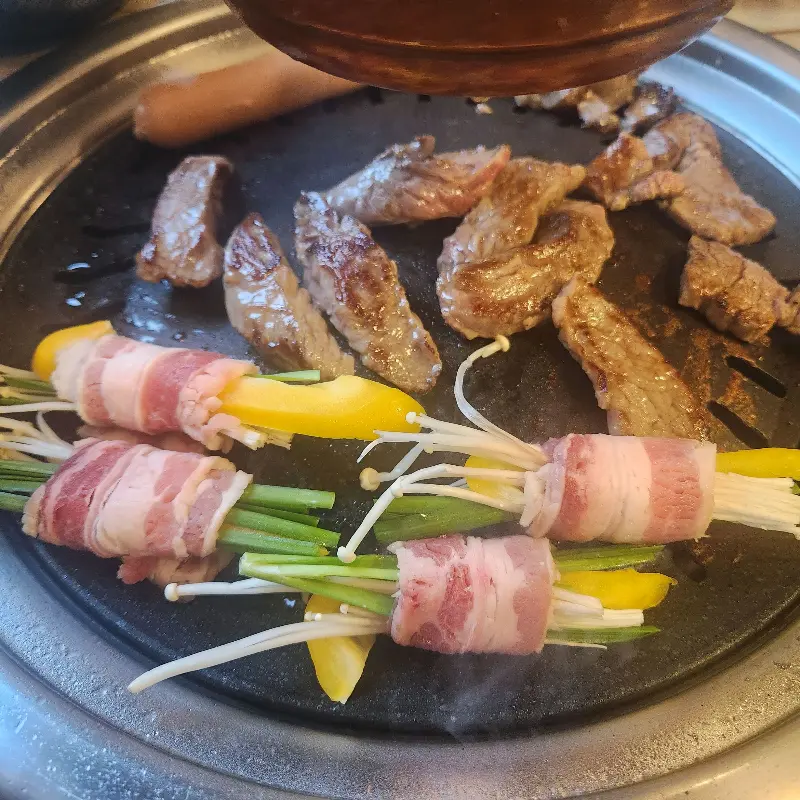 불판 위에 올려진 고기와 야채