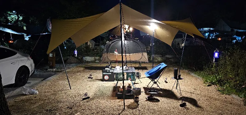 야외 테이블에 놓인 음식과 캠핑 장비