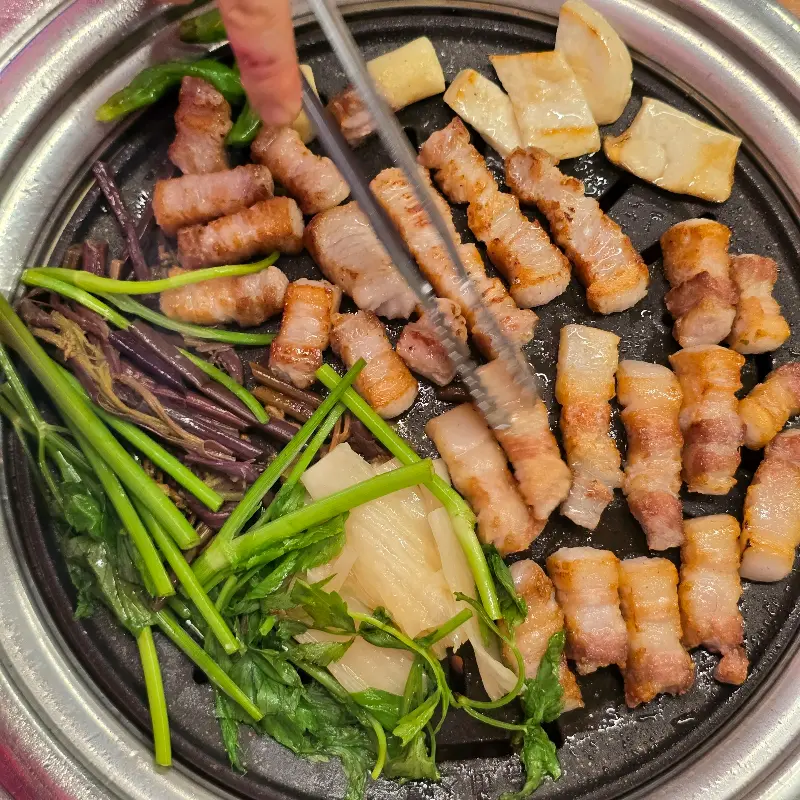 잘 익은 삼겹살 조각과 미나리