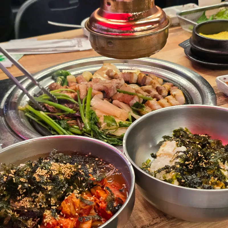 미나리, 떡, 마늘과 함께 구워지는 삼겹살