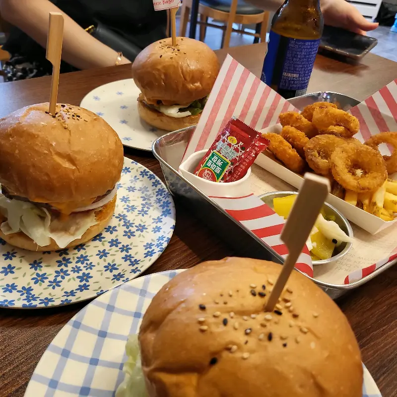 테이블 위에 놓인 수제버거와 사이드 메뉴