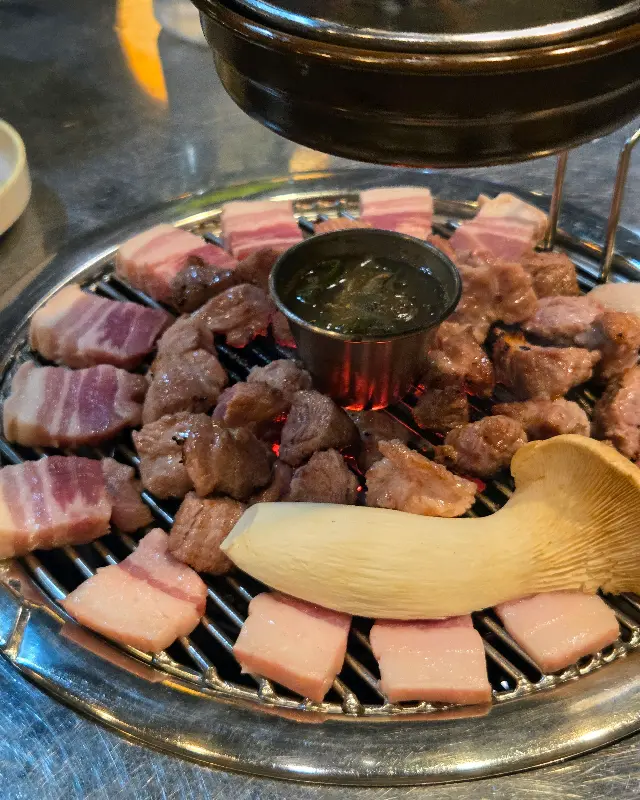 연탄불 위에서 흑돼지와 멜젓이 어우러진 모습