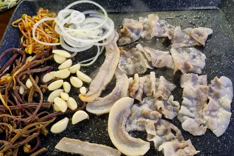 불판 위에 구워진 고기와 채소