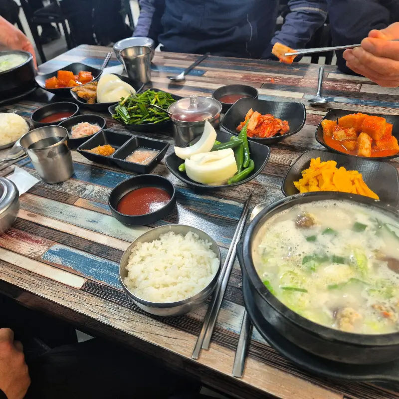 테이블 가득 차려진 국밥과 밑반찬