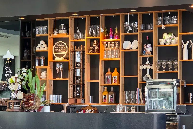 다양한 컵과 수제청이 진열된 카페 내부 모습