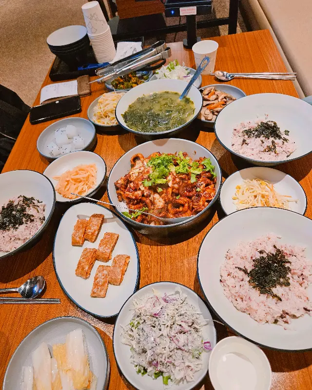 쭈꾸미 볶음과 함께 다양한 밑반찬이 차려진 테이블 전경