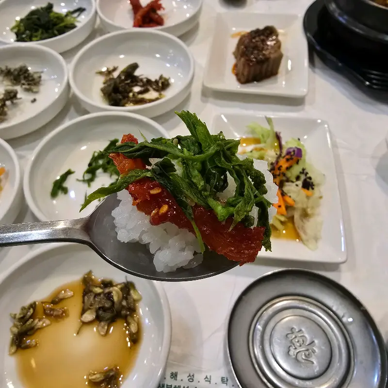 나물과 고추장을 넣어 비빈 비빔밥을 숟가락으로 뜬 모습