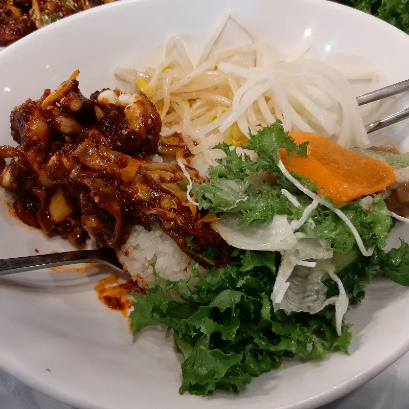 밥 위에 쭈꾸미와 콩나물을 얹어 먹는 모습