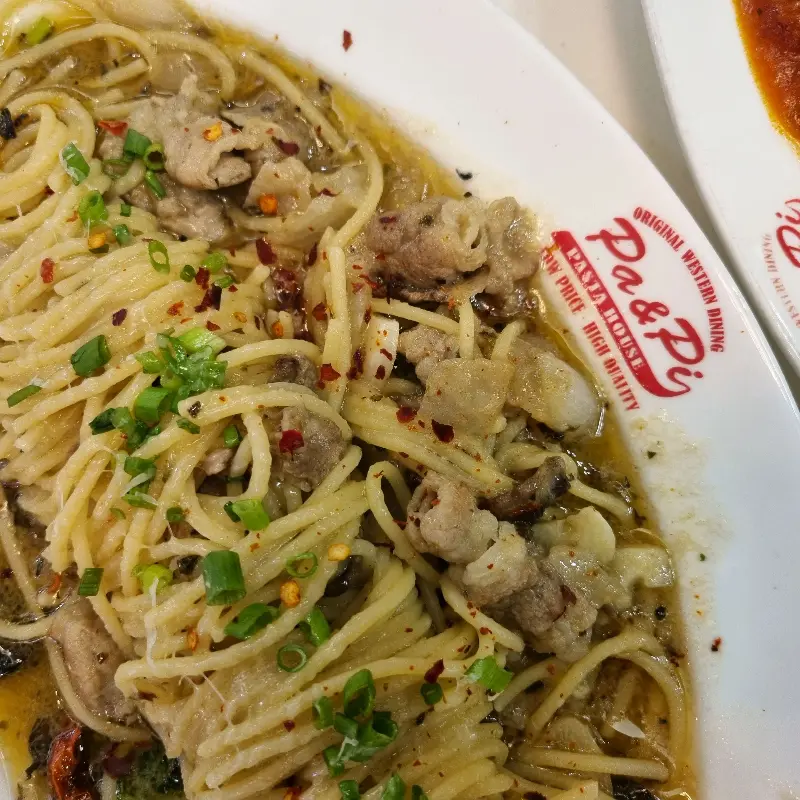 파스타 위에 잘게 썰린 파가 뿌려져 있다.