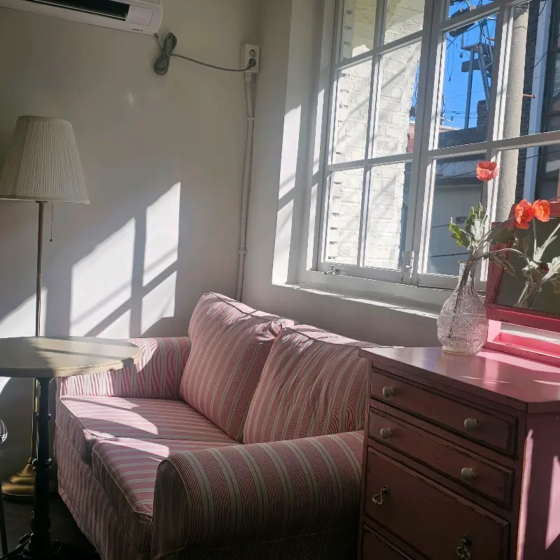 핑크색 소파와 테이블이 놓인 창가 좌석