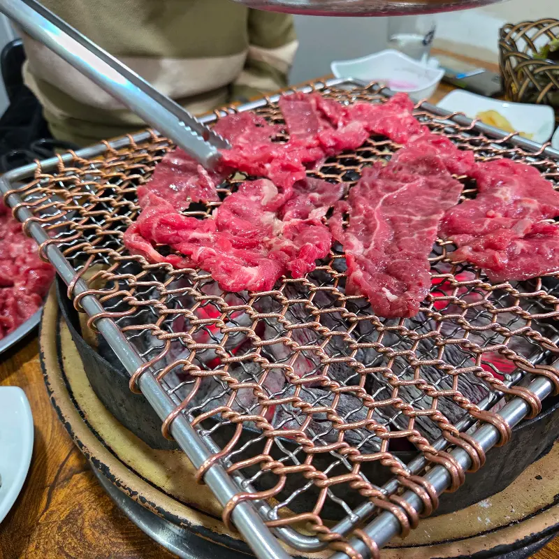 집게로 불고기를 들어올리는 모습