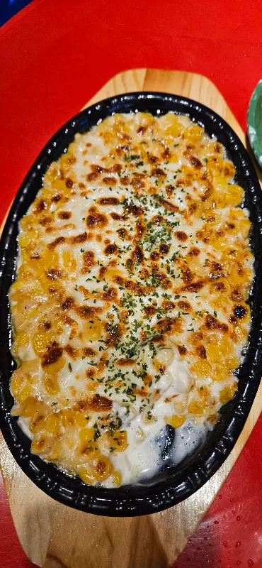 철판 위에 올려진 콘치즈는 뜨거운 열기에 치즈가 녹아 흘러내리고 있었다. 옥수수 알갱이는 윤기가 자르르 흘렀고, 파슬리 가루가 솔솔 뿌려져 있었다.