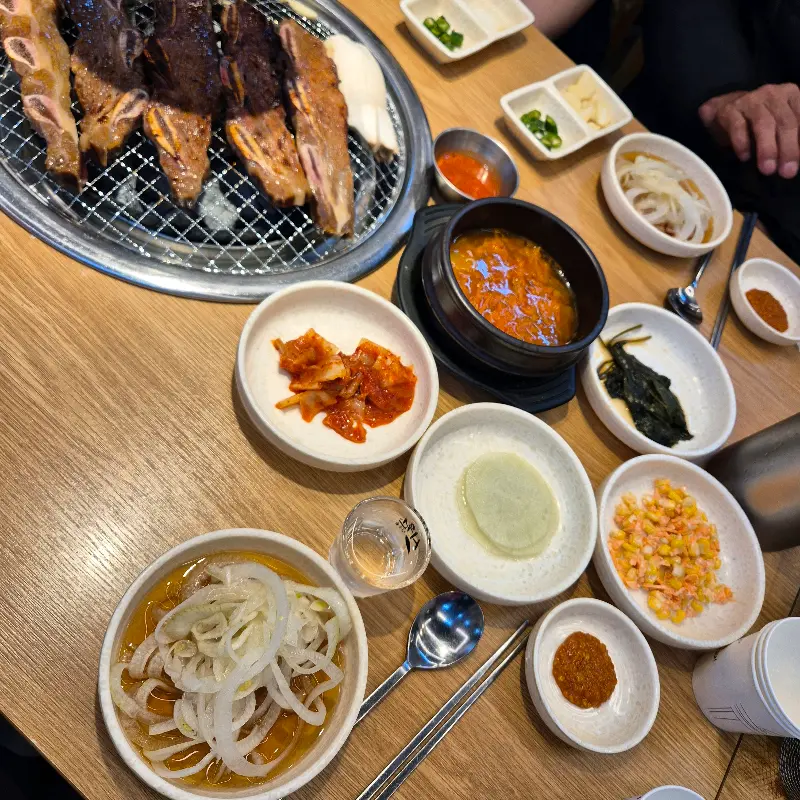 다채로운 밑반찬과 구워지고 있는 고기의 모습