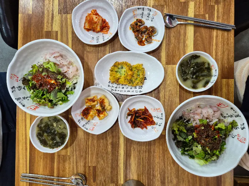 정갈한 밑반찬과 회무침, 물회가 차려진 테이블