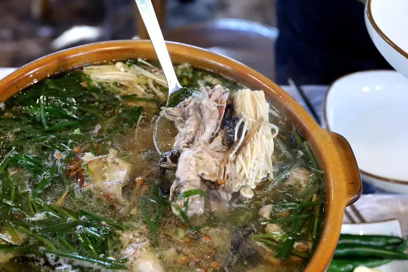 국자로 능이오리백숙을 뜨는 모습