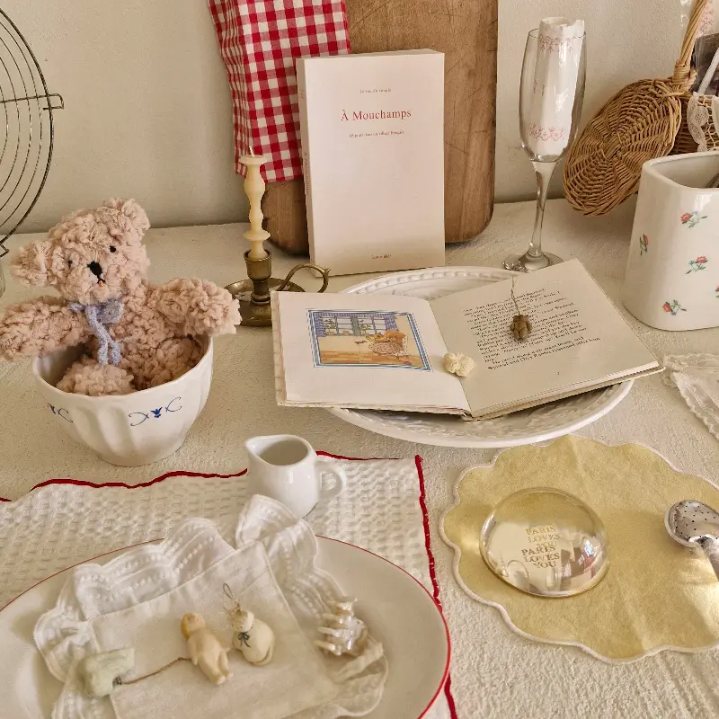 테이블 위에 놓인 찻잔과 책, 곰인형