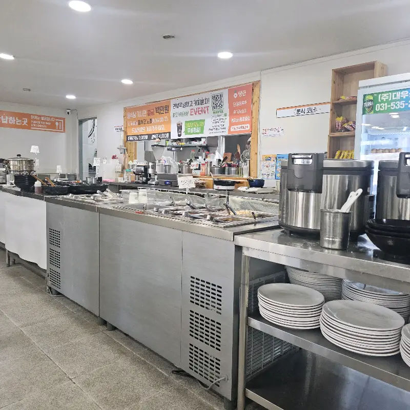 깔끔하게 정돈된 뷔페 테이블과 다양한 음식들이 놓여 있는 '한끼' 내부 전경