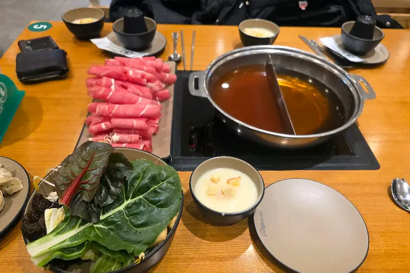 테이블 위에 놓인 샤브샤브 냄비와 신선한 소고기