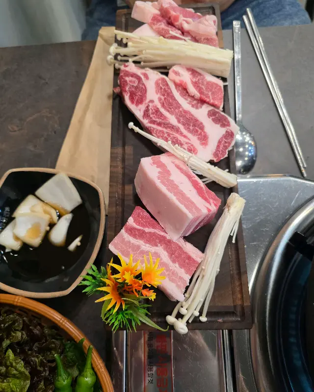 나무 도마에 담겨 나온 삼겹살