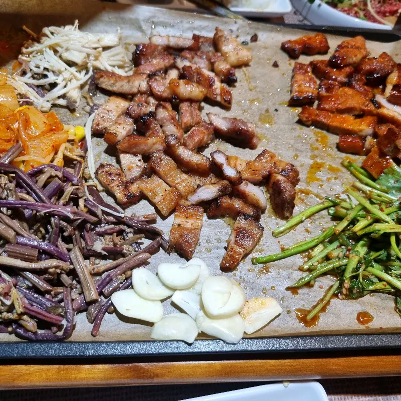 다양한 곁들임 메뉴와 함께 제공되는 고기