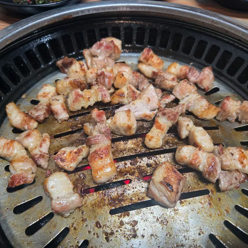 불판 위에서 잘 익은 고기 조각들의 클로즈업 샷