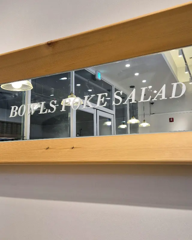 유리창에 'BOWLS POKE SALAD'라고 적혀 있는 모습