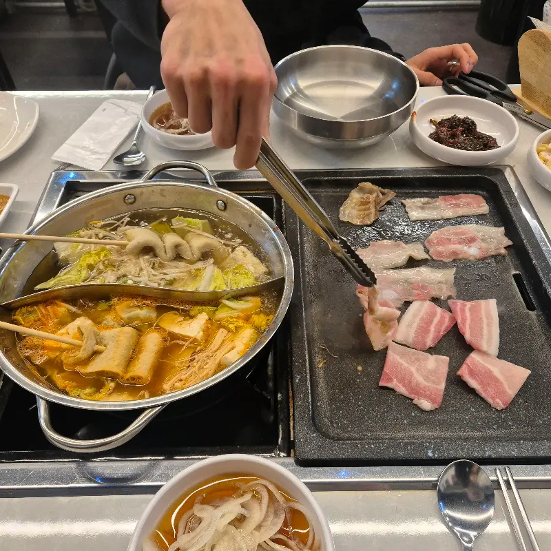 샤브샤브 냄비와 불판 위에서 구워지는 삼겹살